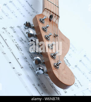 closeup of music sheets and black-and-white electric guitar.isolated on a white background.photo with copy space. Stock Photo