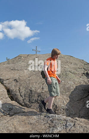 boy with minimalist shoes descending from the summit of Rauchröhren (smoke tubes), Eck, Bavarian Forest, Bavaria, Germany Stock Photo