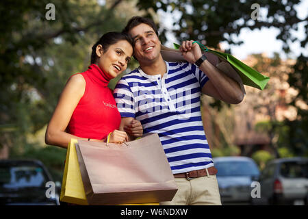 Young couple carrying shopping bags and smiling Stock Photo