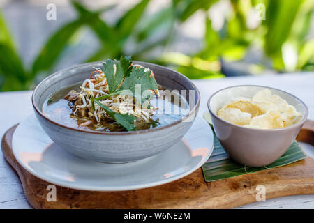 Sop Buntut, oxtail soup with potato, carrot and been sprouts. Served with potato chips. Traditional Indonesian cuisine. Stock Photo