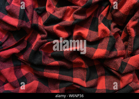 Wrinkled black and red cell clothes background. Fabric with black red cages pattern. Plaid material. Crumpled Cloth Blank Background Stock Photo