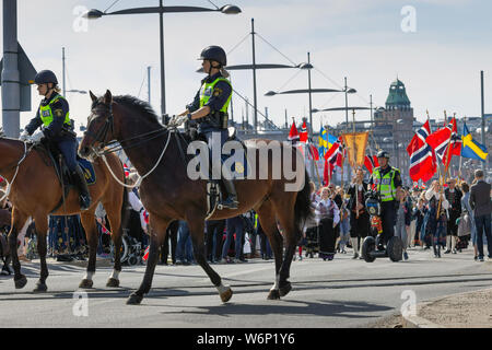 Stockholms police officers on their horses, patrol during the Norwegians annual patriotic national independence day celebration events in Sweden Stock Photo