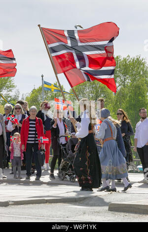 Norwegian patriotic women holding national flags and crowds looking on during their parade to celebrate Norway's independence day in Skansen, Sweden Stock Photo