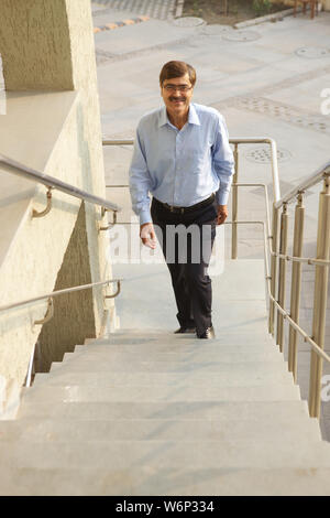 Man climbing up stairs Stock Photo