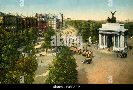 Wellington Arch and Quadriga, London, c1915. View of the Wellington Arch, a triumphal arch in central London between Hyde Park and Green Park. It was designed by Decimus Burton and built 1826-1830, and once supported an equestrian statue of the 1st Duke of Wellington. The sculpture of the quadriga, (an ancient four-horse chariot), designed by Adrian Jones, has been mounted on it since 1912. Postcard. Stock Photo