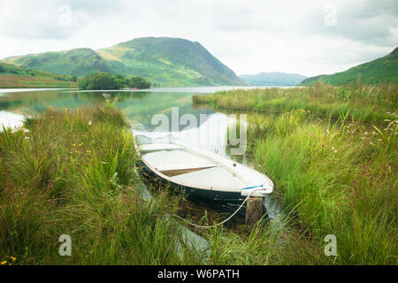A boat moored on Crummock Water in The Lake District National Park. UK Stock Photo