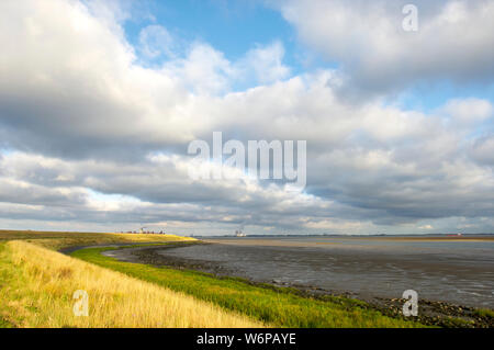 The Western Scheldt at low tide and the dike used as farmland with the Doel nuclear power plant cooling towers in the background on Walcheren in Zeela Stock Photo