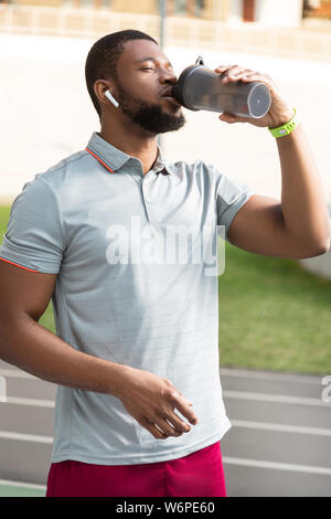 Serious sportive African American young man standing outdoors Stock Photo