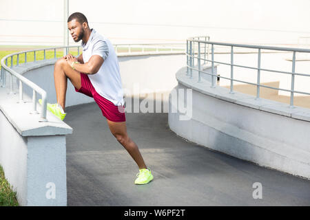 Young dark-haired motivated male athlete in summer sportswear Stock Photo