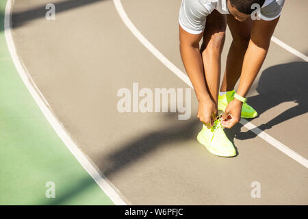 Young male athlete tying laces at the stadium Stock Photo