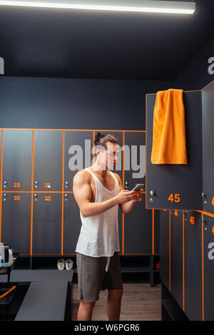Pleasant good looking man standing with his phone Stock Photo
