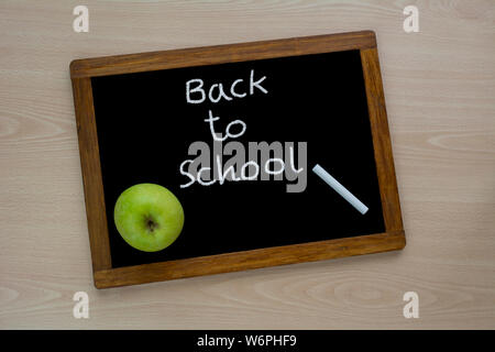 Back to school, the inscription on the mini-Board, the layout of the Board and chalk on the desk , with green apple. the concept of preparation for sc Stock Photo