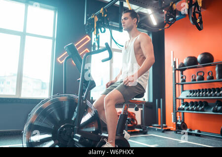 Handsome well built man working on his leg muscles Stock Photo