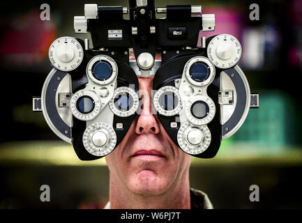 Lt. Col. David Miller, an optometrist assigned to the 442nd Medical Squadron at Whiteman Air Force Base, Missouri, assists in setting up a phoropter which was used to give eye exams in Hayesville, North Carolina. Stock Photo