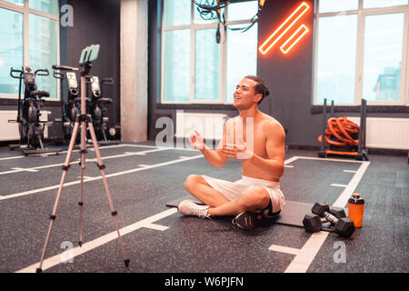 Joyful happy man sitting in front of the camera Stock Photo