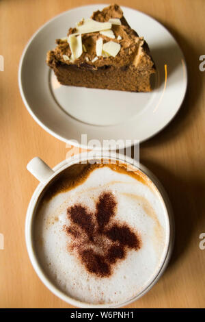 Coffee and cake in a National Trust cafe at a stately home / house. The the cappuccino coffee has the National Trust Oakleaf trademark logo in sprinkled chocolate. UK (110) Stock Photo