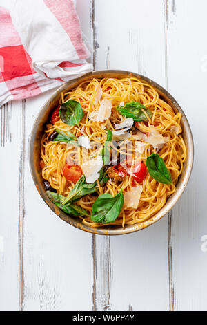 Pasta with aubergines, tomato sauce and fresh basil served with parmesan Stock Photo