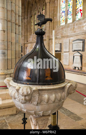 Baptismal font in the nave of Exeter Cathedral; in the Southwest corner of the nave is the baptismal font (1687) carved from Sicilian marble with an oak cover inlaid with eight figures of apostles. Exeter, UK. (110) Stock Photo