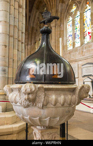 Baptismal font in the nave of Exeter Cathedral; in the Southwest corner of the nave is the baptismal font (1687) carved from Sicilian marble with an oak cover inlaid with eight figures of apostles. Exeter, UK. (110) Stock Photo