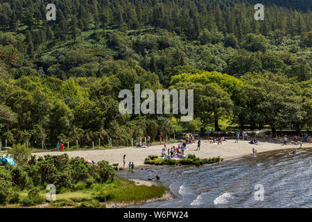 Daytrippers paddling in the upper lake on a hot summer day in Glendalough, County Wicklow, Ireland Stock Photo