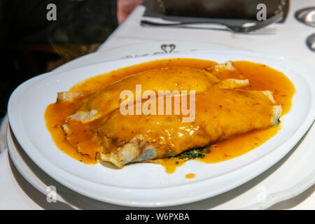 Vegetarian stuffed pasta noodle with red sauce served on top Stock Photo