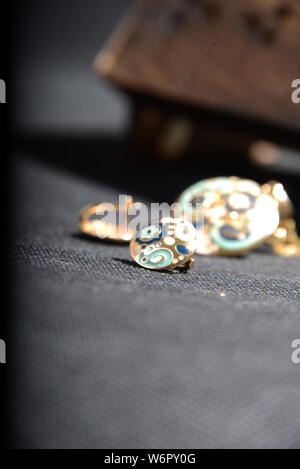 jewellery on the  little blue rhino statue hold the jewellery holder blue necklace gold rings blue and gold rings with Gray background pretty animal Stock Photo