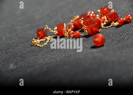 red gold jewellery on the box close up very beautiful with Gray background shiny bracelet or necklace earrings orange crystal