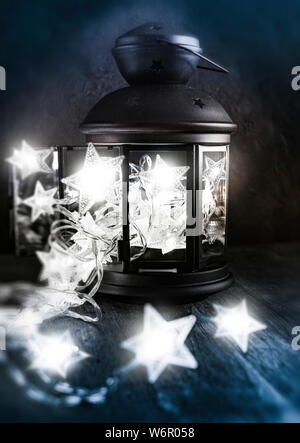 Christmas LED star lights pushed into a lantern to create an unusual seasonal still life. Stock Photo