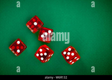 five rolling red dices on green background Stock Photo