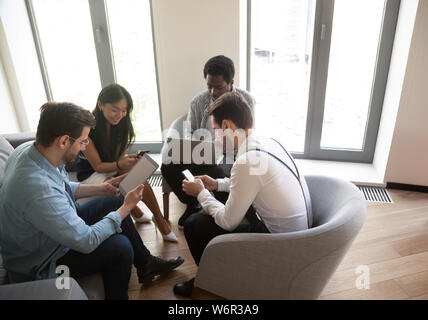 Diverse business people using devices at meeting in office Stock Photo