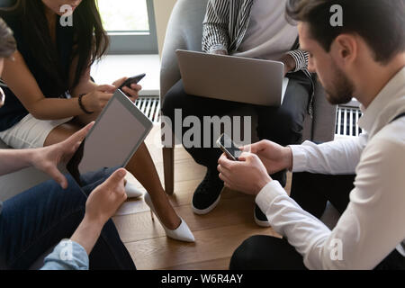 Business people group sitting in circle using devices, close up Stock Photo