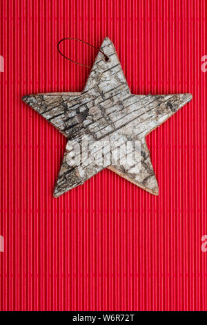 Beautiful star of birch bark on red corrugated cardboard background. Ready for Christmas greeting. Stock Photo