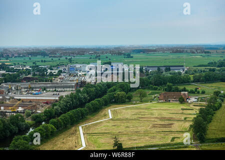 Diksmuide, Flanders, Belgium -  June 19, 2019: View on farms and farm land and industrial area with Deceuninck plant from up IJzertoren, tallest peace Stock Photo
