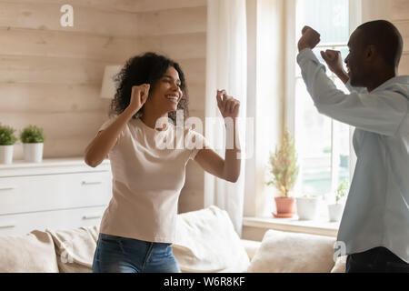 Cheerful african couple dancing in living room Stock Photo