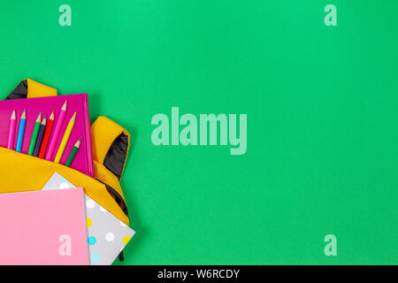 Back to school concept. Backpack with school supplies on green background. Top view Stock Photo