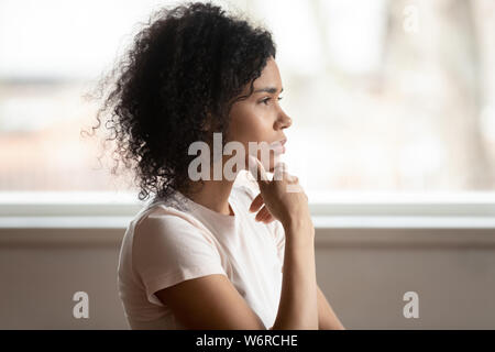 Pensive mixed race woman thinking makes decision, side view Stock Photo