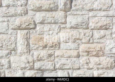 Light fragment of an old limestone stone block wall for use as an abstract background and texture. Stock Photo