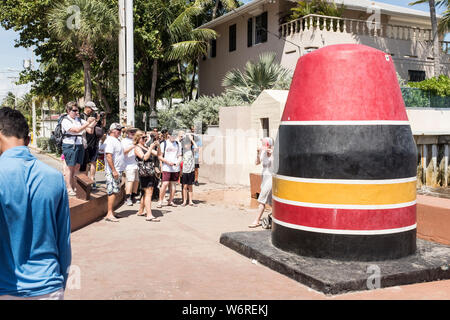 Tourists gather around waiting to take photos of the monument marking the southernmost point of the United States in Key West, Florida Stock Photo