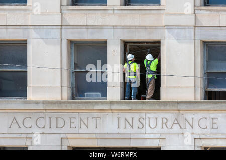Detroit, Michigan - Two construction workers on a ledge on the third floor of the Standard Accident Insurance Company building. Built in 1920, the str Stock Photo