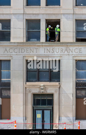 Detroit, Michigan - Two construction workers on a ledge on the third floor of the Standard Accident Insurance Company building. Built in 1920, the str Stock Photo