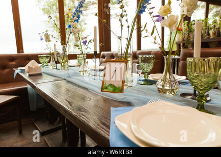 Decorations and wildflowers served on the festive table, wedding celebration concept Stock Photo