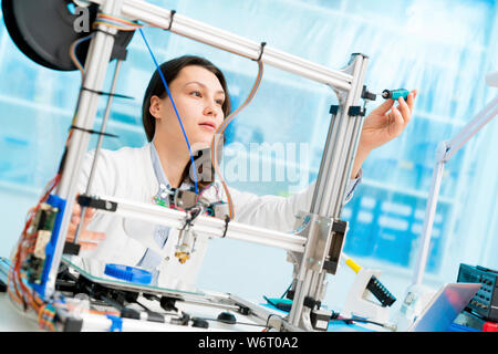Technician working on 3D printer. Stock Photo