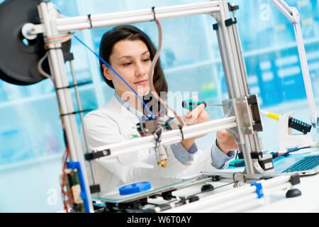 Technician working on 3D printer. Stock Photo