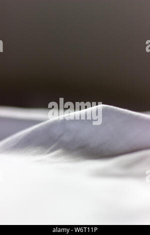 Folds in white cloth close up in shallow depth of field Stock Photo