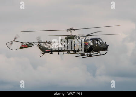 Two vintage British Army helicopters from the Historic Army Aircraft Flight flying in close formation at the RNAS Yeovilton, UK Air Day on 13/7/19. Stock Photo