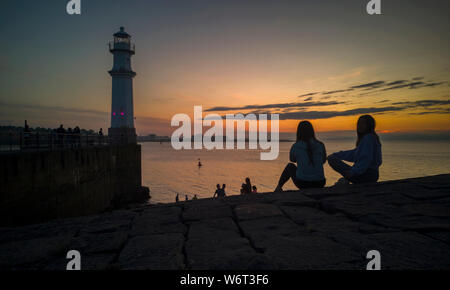 Scotland Edinburgh Newhaven Harbour Lighthouse 2nd August 2019 Youngsters gather to watch the sunset at local landmark of Newhaven Lighthouse, on the Firth of Forth, Edinburgh, Scotland. Pic Credit: phil wilkinson/Alamy Live News Stock Photo