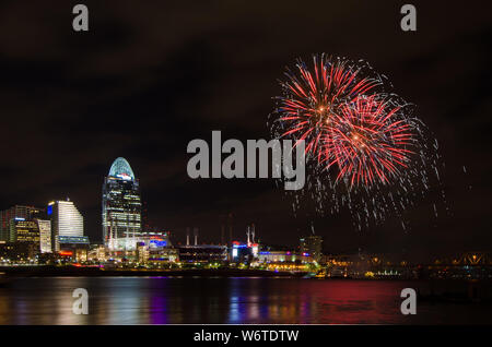 Fireworks launch from a barge in the Ohio River in Cincinnati, Ohio, USA, against the Cincinnati cityscape, including Great American Ball Park. Stock Photo