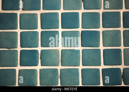 Close-up of blue and vintage-style tiles that form a grid of small white squares Stock Photo