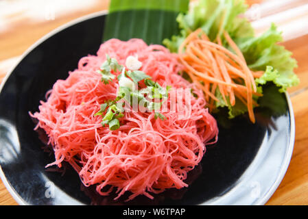 Rice vermicelli pink frying and vegetable / Stir fried rice noodles with red sauce served on plate on the wooden table , Thai Asian style noodles Stock Photo