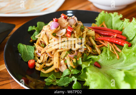 Bamboo shoot dry soup shredded cooked with herbs and spices ingredients and fresh lettuce vegetable / Thai bamboo shoot spicy salad served on plate on Stock Photo